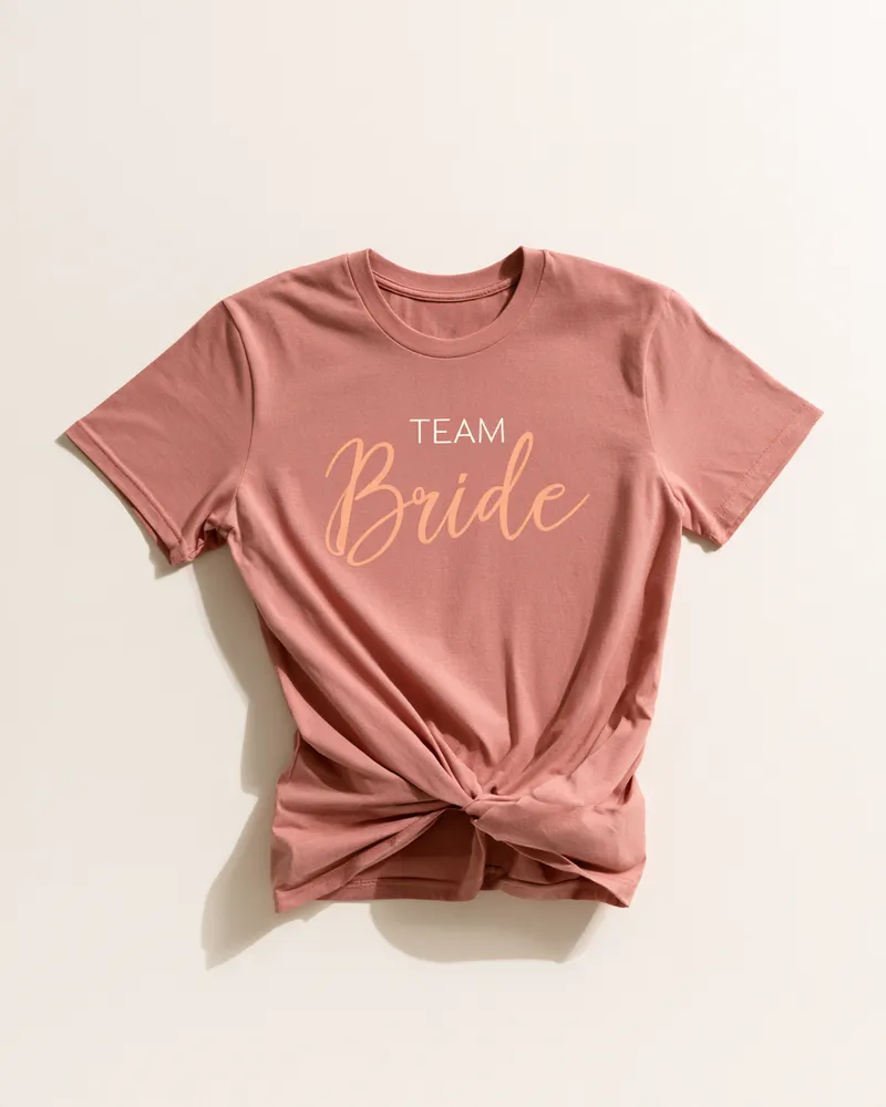 Altrosa T-Shirt mit „Team Bride“-Schriftzug in Apricot, vorne geknotet – Outfit für die Freundinnen der Braut beim Junggesellinnenabschied